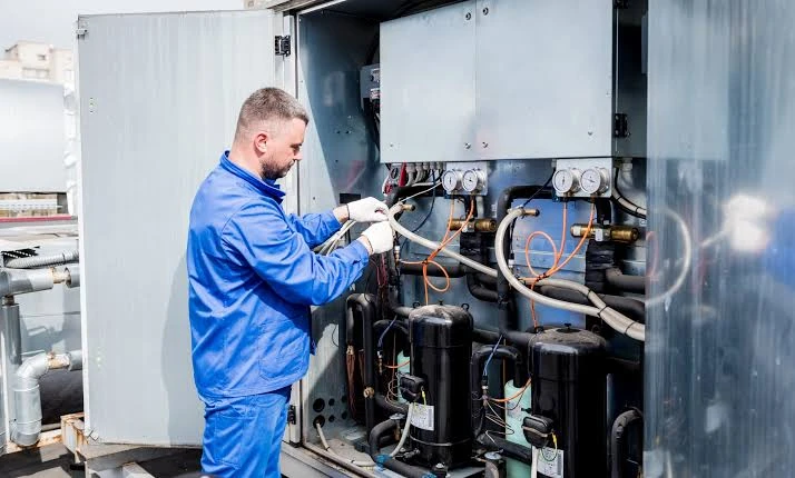 Technician inspecting ventilation airflow and whole-home filtration equipment