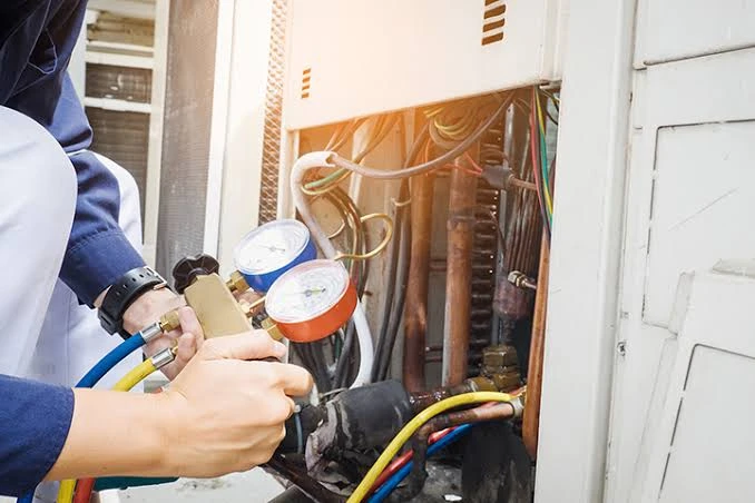 Technician testing system pressures with diagnostic gauges during emergency call