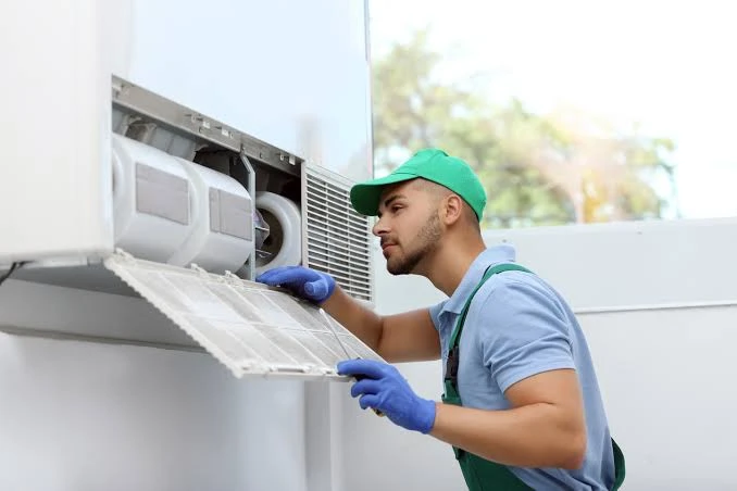 Technician inspecting and cleaning indoor residential air filters