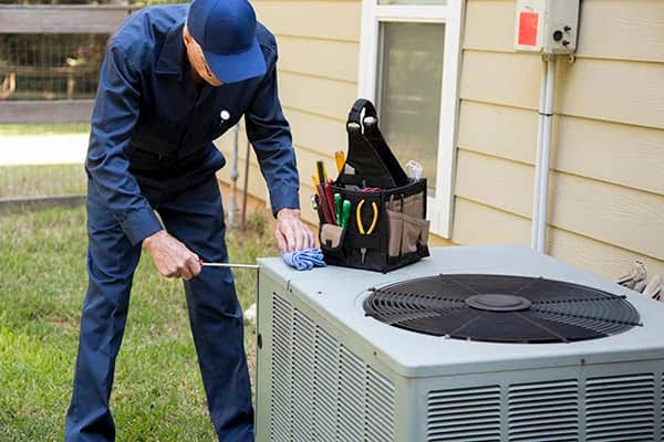 Technician inspecting residential air conditioning and heat pump equipment